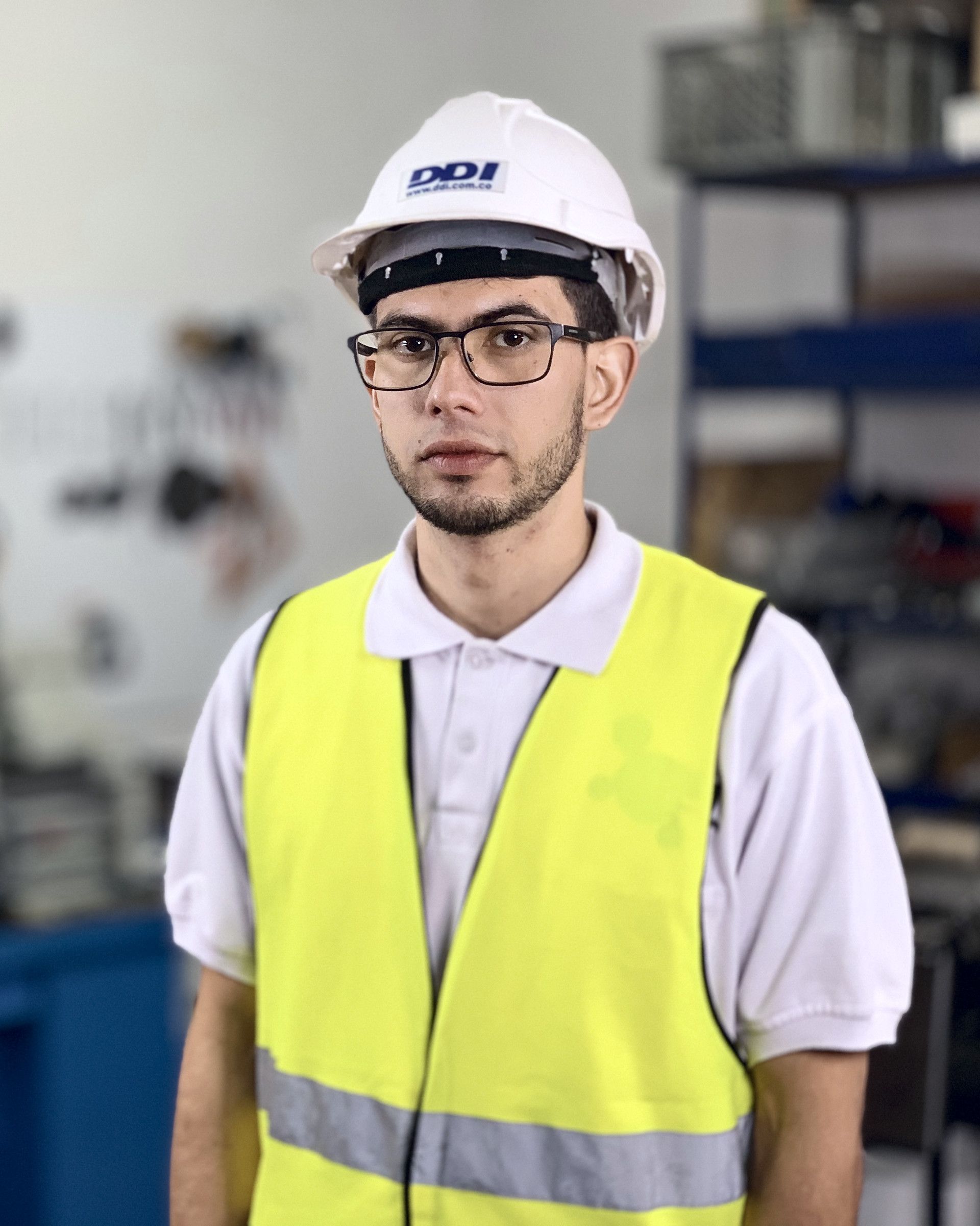 DDI engineer in a DDI hard hat and high-visibility vest in the workshop